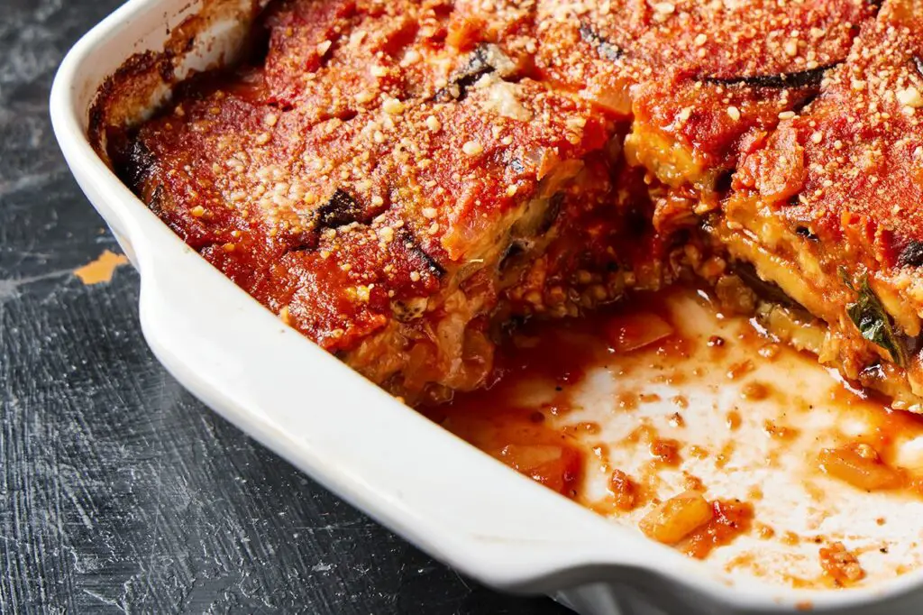 <p> Eggplant Parmesan is one of those classic dishes that proves vegetarian doesn’t mean boring. Sliced eggplant rounds are lightly breaded, baked until crisp, and then layered with marinara sauce and shredded mozzarella cheese. A sprinkle of Parmesan and a final bake in the oven creates a bubbly, golden topping that’s as comforting as anything you’d find in a classic Italian kitchen. The baked method keeps the dish lighter on calories and fat, without losing the crispy texture we all crave. It pairs beautifully with a green salad or whole-grain pasta, and it’s a great option to make ahead and reheat when life gets busy. </p> :: Milk Street