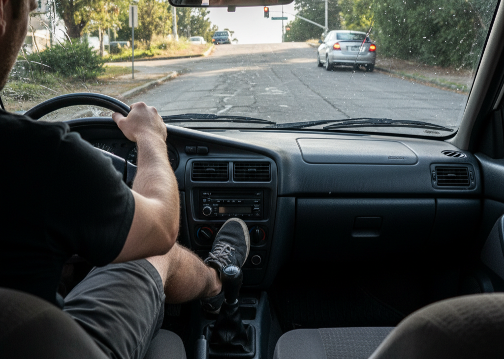 <p> If you have ever been stuck on a hill at a stoplight, you know how intimidating it can be to balance the clutch and gas without rolling back. Many drivers try to “hold” the car in place with the clutch alone, but this is one of the fastest ways to burn it out.

Instead, use your parking brake to keep the car still. When it is time to move, release the brake as you slowly let out the clutch and apply gas. It gives you more control, eliminates panic about rolling into the car behind you, and keeps your clutch from taking a beating every time you are on an incline. </p> :: Gemini
