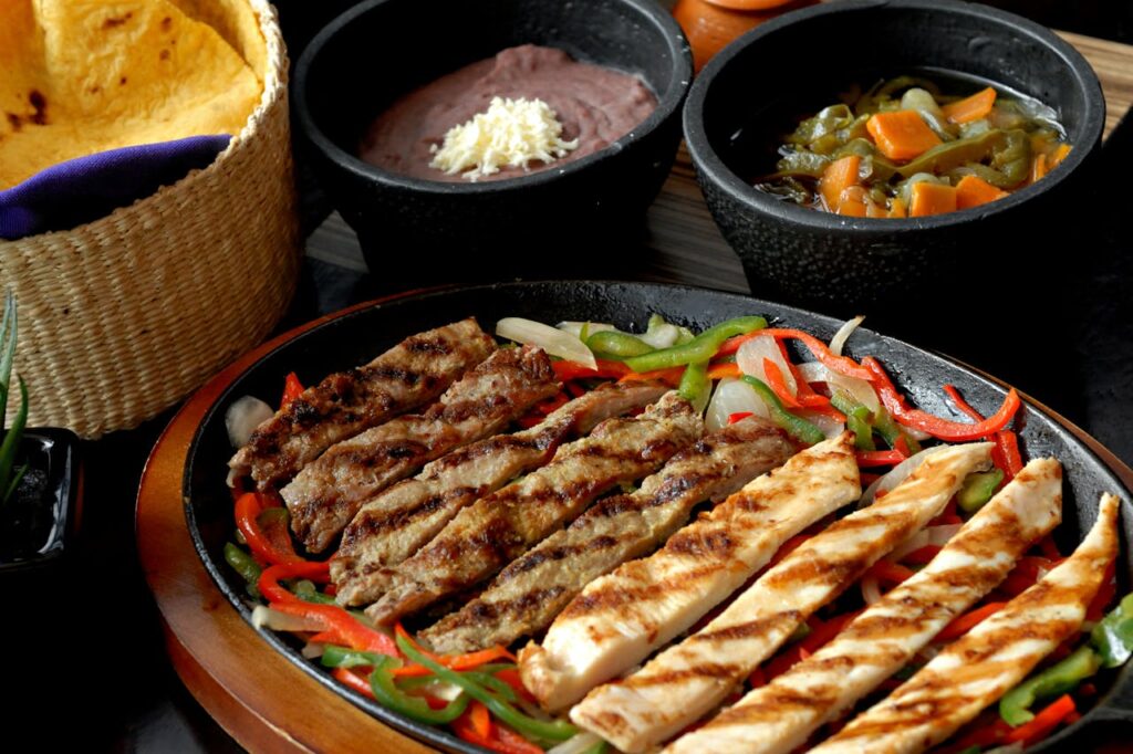1. Sizzling Cast Iron Fajitas <p> There is something almost theatrical about fajitas served on a hot cast iron skillet. Before you even take a bite, you hear that unmistakable sizzle, which instantly grabs your attention. The smell of seasoned meat mixed with onions and peppers fills the air, making it hard to wait. Visually, the bright mix of colors feels lively and inviting. When you finally dig in, the textures do their part too. You get tender meat, slightly crisp vegetables, and soft tortillas all working together. To make this even more engaging at home, serve everything family-style and let people build their own wraps. That simple step turns dinner into an experience rather than just a meal. </p> :: Pexels